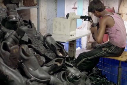 Garoto trabalha na produção de sapatos