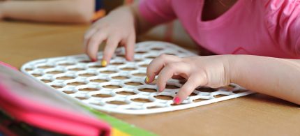 Criança brinca com jogo educativo